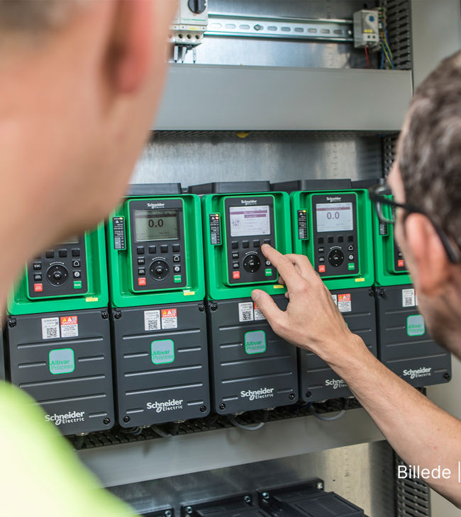 To teknikere arbejder på anlæg hos Schneider-Electric