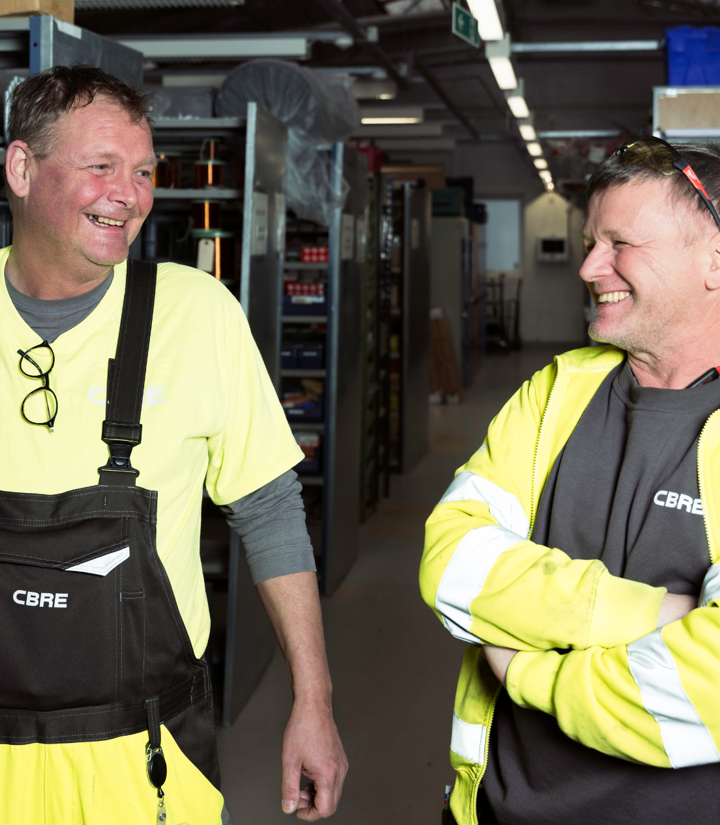 To CBRE elektrikere arbejder på et lager i en bygning