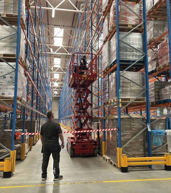 CBREs facility teamleder hos Normal står i logistikhal og hjælper en fra sit vedligeholdsteam