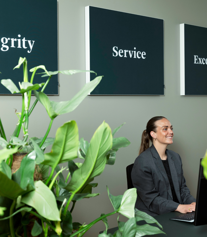 CBRE medarbejder sidder på kontoret med RISE værdi plakaterne i baggrunden